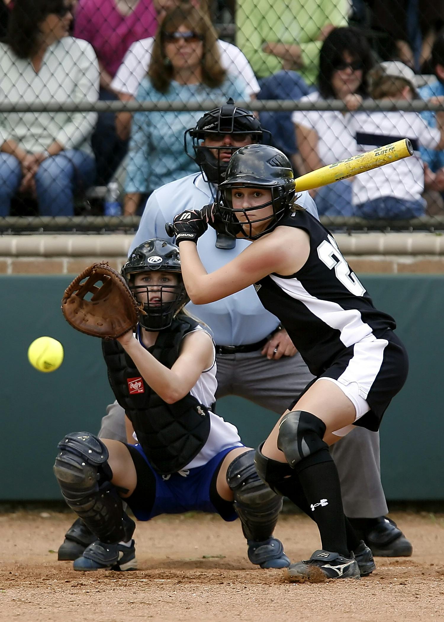 Exciting softball game with catcher and batter in action, capturing the energy of female athletes.